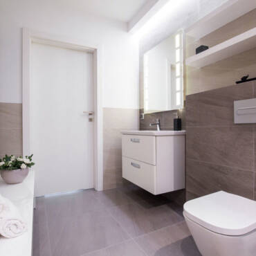 Image of spacious light bathroom with grey tiling